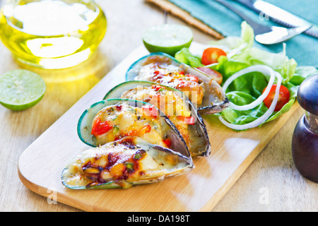 Cozze al forno con formaggio e insalata mista Foto Stock