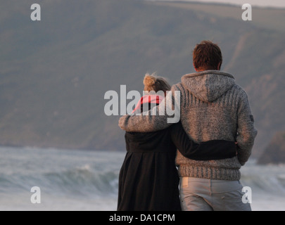 Amorevole coppia giovane a piedi lungo la spiaggia di sera, Cornwall, Regno Unito 2013 Foto Stock