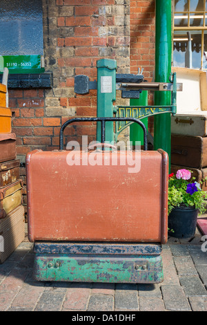 Valigia Vintage bsing pesato sulla vecchia ferrovia scale. Foto Stock