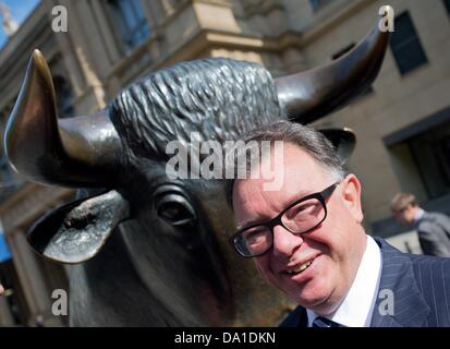 Deutsche Boerse Group CEO Reto Francioni sorge accanto alla bull in occasione del DAX' XXV anniversario di fronte alla borsa di Francoforte sul Meno, Germania, 01 luglio 2013. Il toro simboleggia la tendenza al rialzo dei prezzi. Foto: Boris Roessler Foto Stock