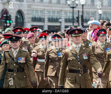 Un funzionario che portano un contingente dell esercito e i partecipanti al London Pride Parade. Foto Stock