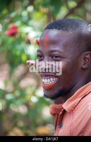 Una guida viene illustrato l'utilizzo dell'impianto di Spezie Annato come "Zanzibar rossetto". Zanzibar, Repubblica Unita di Tanzania. Foto Stock