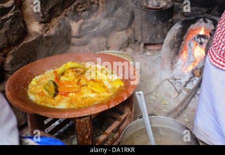 Tagine berbera realizzato oltre ad aprire il fuoco in un Atlas mountain village Foto Stock