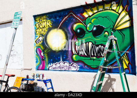 Murale su una parete nella zona di Funk a Santa Barbara in California con artista materiali e una scaletta. Foto Stock