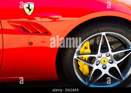 Vista dettagliata del rosso Ferrari California che mostra il badge, sfiato, PARAFANGO ANTERIORE, RUOTA, pneumatici e freni. Foto Stock