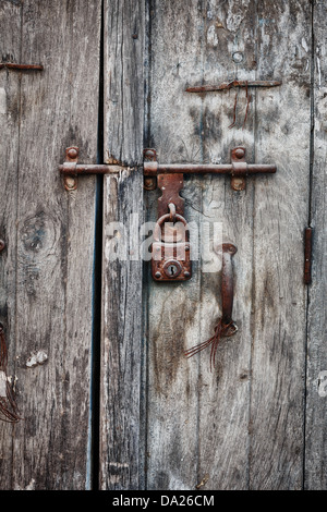 Lucchetto arrugginito su una vecchia porta di legno della casa indiana Foto Stock