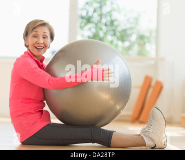 Senior donna esercizio con palla fitness Foto Stock