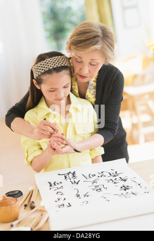 Nonna e nipote (8-9) pittura simboli giapponesi Foto Stock