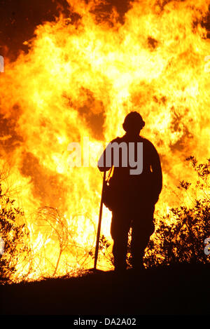 25 ottobre 2007 - San Bernardino, in California, Stati Uniti d'America - il lavoro dei vigili del fuoco di una battaglia che infuria wildfire in San Bernardino zona della California nel mese di ottobre 2007. Il fuoco ha distrutto più di 1.500 case e bruciato oltre 500.000 acri. È stato dichiarato uno stato di emergenza in sette contee della California come più di 6 mila i vigili del fuoco hanno lavorato per la lotta contro l'incendio. Almeno 60 dei vigili del fuoco sono stati feriti combattere l'incendio. (Credito Immagine: © Nicolaus Czarnecki/ZUMAPRESS.com) Foto Stock