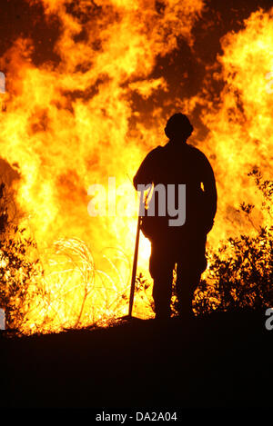 25 ottobre 2007 - San Bernardino, in California, Stati Uniti d'America - il lavoro dei vigili del fuoco di una battaglia che infuria wildfire in San Bernardino zona della California nel mese di ottobre 2007. Il fuoco ha distrutto più di 1.500 case e bruciato oltre 500.000 acri. È stato dichiarato uno stato di emergenza in sette contee della California come più di 6 mila i vigili del fuoco hanno lavorato per la lotta contro l'incendio. Almeno 60 dei vigili del fuoco sono stati feriti combattere l'incendio. (Credito Immagine: © Nicolaus Czarnecki/ZUMAPRESS.com) Foto Stock