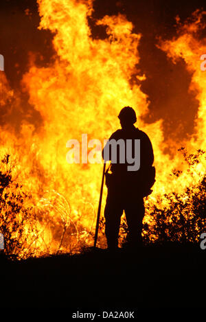 25 ottobre 2007 - San Bernardino, in California, Stati Uniti d'America - il lavoro dei vigili del fuoco di una battaglia che infuria wildfire in San Bernardino zona della California nel mese di ottobre 2007. Il fuoco ha distrutto più di 1.500 case e bruciato oltre 500.000 acri. È stato dichiarato uno stato di emergenza in sette contee della California come più di 6 mila i vigili del fuoco hanno lavorato per la lotta contro l'incendio. Almeno 60 dei vigili del fuoco sono stati feriti combattere l'incendio. (Credito Immagine: © Nicolaus Czarnecki/ZUMAPRESS.com) Foto Stock