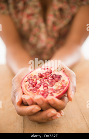 Close up della donna e delle sue mani frutto di melograno Foto Stock