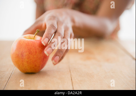 Donna raggiungendo a mano per Apple Foto Stock