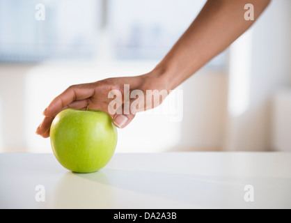 Donna raggiungendo a mano per Apple Foto Stock