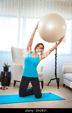 Fitness trainer dimostra esercizi a casa con sfera di fitness Foto Stock