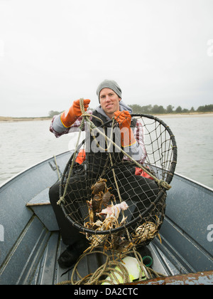 Stati Uniti d'America, Oregon, Rockaway Beach, Ritratto di uomo con i granchi in net Foto Stock