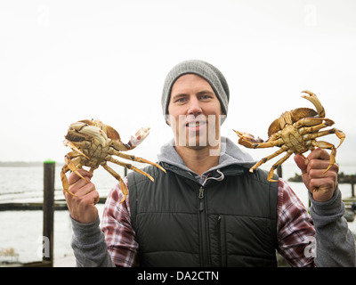 Stati Uniti d'America, Oregon, Rockaway Beach, Ritratto di uomo che mostra i granchi Foto Stock