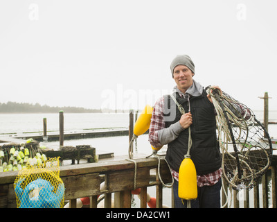 Stati Uniti d'America, Oregon, Rockaway Beach, Ritratto di uomo con attrezzature per la pesca Foto Stock