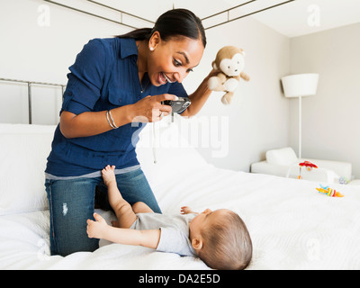 Madre giocando con suo figlio (2-5 mesi) prendendo la sua immagine Foto Stock