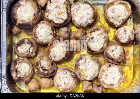 I Funghi ripieni sul grill....farcite con aglio, olio di oliva, formaggio, prosciutto, pancetta.... Foto Stock