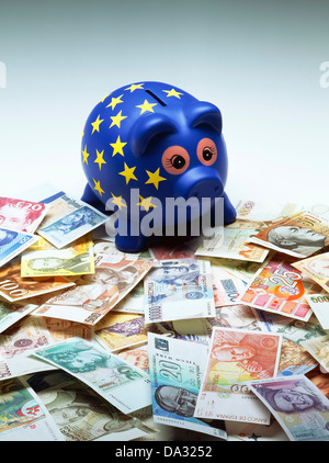 Blu europeo piggy banca decorata con stelle gialle e banconote ex dei paesi europei che formano l'euro Foto Stock