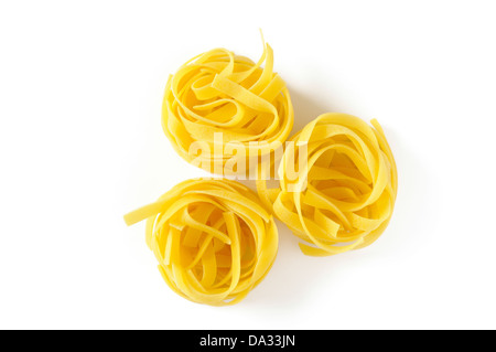 Fettuccine italiana disposti in nidi su sfondo bianco Foto Stock