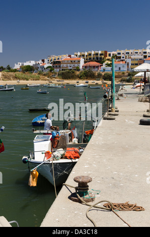 I pescatori reti di carico su una barca da pesca in Ferragudo in Algarve Foto Stock