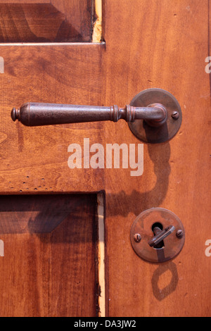 Ferro da stiro maniglia della porta su una vecchia porta di legno Foto Stock