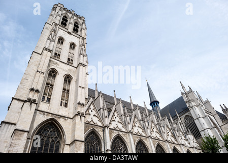 Cattedrale di San Michele e Santa Gudula Esterno Bruxelles Belgio | BRUXELLELS, Belgio — Una vista a bassa angolazione cattura una torre e i contrafforti della Cattedrale di San Michele e Santa Gudula contro un cielo pallido, con la guglia in ardesia dell'incrocio che si eleva dietro. I contrafforti sostengono la navata costruita durante la campagna gotica di circa 250 anni iniziata nel 1226 su una collina un tempo sede di una chiesa romanica dell'XI secolo. Foto Stock