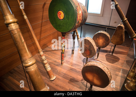 BRUXELLES, Belgio — Una collezione di tamburi e corni asiatici in mostra al Musical Instrument Museum di Bruxelles. Questa mostra espone diversi strumenti a percussione e a fiato provenienti da diverse culture asiatiche, mettendo in evidenza le ricche tradizioni musicali del continente. Foto Stock