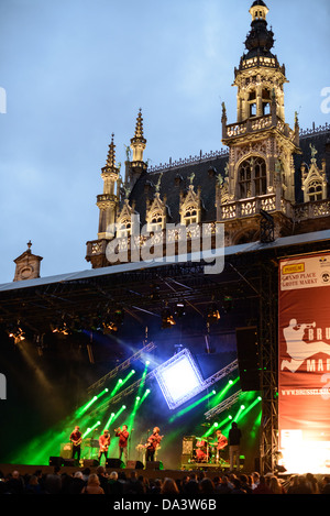 BRUXELLES, Belgio — la band belga Opmoc suona su un palco alla Brussels Jazz Marathon nella Grand Place di Bruxelles. Originariamente la piazza del mercato centrale della città, la Grand-Place è ora un sito patrimonio dell'umanità dell'UNESCO. Gli edifici ornati fiancheggiano la piazza, tra cui le sale di gilda, il municipio di Bruxelles e la Breadhouse, e sette strade acciottolate vi si immettono. Sullo sfondo, dietro il palco, si trova la Maison du ROI (o Broodhuis / "Casa del pane") che ospita il Museo della città di Bruxelles. Foto Stock