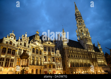 BRUXELLES, Belgio — Hotel de Ville nella Grand Place, Bruxelles, al crepuscolo. Originariamente la piazza del mercato centrale della città, la Grand-Place è ora un sito patrimonio dell'umanità dell'UNESCO. Gli edifici ornati fiancheggiano la piazza, tra cui le sale di gilda, il municipio di Bruxelles e la Breadhouse, e sette strade acciottolate vi si immettono. Foto Stock