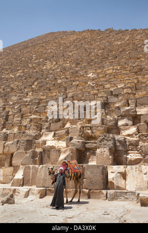 Uomo e cammello accanto alla grande Piramide di Giza, noto anche come piramide di Khufu e piramide di Cheope, Giza, il Cairo, Egitto Foto Stock