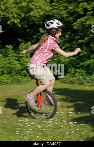 Ragazza giovane su un monociclo Foto Stock