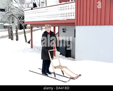 Una signora con un kick-sledge per andare a fare shopping su isole Lofoten in Norvegia Foto Stock