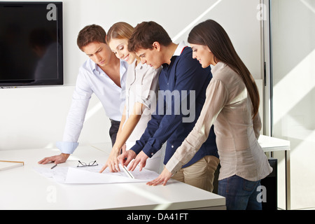 Team di architetti che lavorano insieme sul piano di costruzione in un ufficio Foto Stock