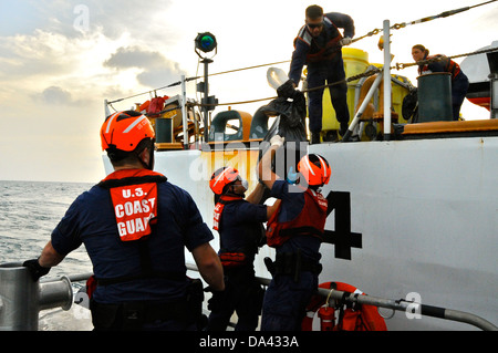 I membri dell'equipaggio a bordo del guardacoste trasferimenti Northland balle di contrabbando a una stazione della Guardia Costiera Miami 45 piedi barca di risposta - Medio equipaggio dalla stazione Miami Beach, Florida, durante un trasferimento di mare Luglio 1, 2013. In totale, 1.250 libbre di cocaina Foto Stock