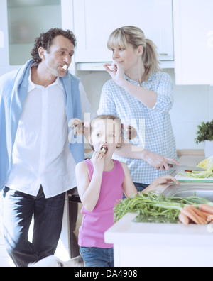 Famiglia facendo una sana insalata in cucina Foto Stock