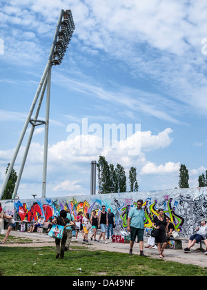 Coperto di graffiti muro di Berlino e il montante del proiettore della Friedrich Ludwig Jahn Sportpark - Mauer Park, Berlino Foto Stock