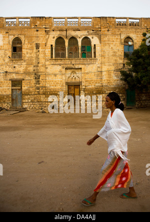 Donna passando davanti ad una architettura ottomana edificio, Massaua, in Eritrea Foto Stock