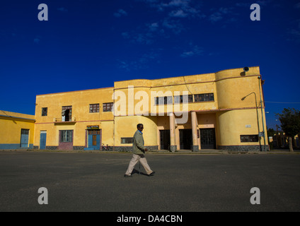 L'uomo passando davanti ad un vecchio stile coloniale italiano Cinema Teatro, Dekemhare, Eritrea Foto Stock