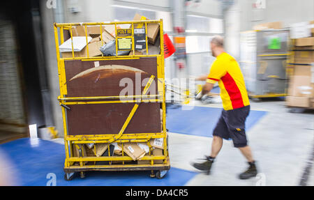 Un membro del personale della Deutsche Post DHL spedizione carichi di servizio il suo furgone per consegne presso il recentemente inaugurato la spedizione hub di DHL a Berlino, Germania, 3 luglio 2013. La struttura ha la capacità di elaborare fino a 8000 pacchetti e pacchi al giorno. Foto: Hannibal Hanschke Foto Stock