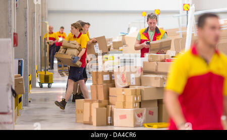 Il personale della Deutsche Post DHL il servizio di spedizione caricare i loro camion di consegna presso il recentemente inaugurato la spedizione hub di DHL a Berlino, Germania, 3 luglio 2013. La struttura ha la capacità di elaborare fino a 8000 pacchetti e pacchi al giorno. Foto: Hannibal Hanschke Foto Stock