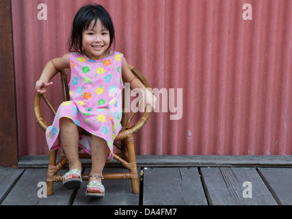 Bambina seduti sulla sedia sorridente clan di saldatura Quay Piers, Georgetown, Penang, Malaysia Foto Stock