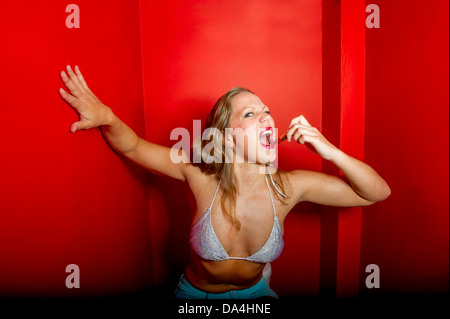 Una giovane donna graziosa applicazione rossetto rosso Foto Stock