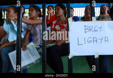 GENERAL Santos, Filippine, 4 luglio, 2013. I residenti nel sud della città filippina di General Santos attendere il loro turno per ricevere sovvenzioni dal governo, Luglio 4, 2013. Sotto condizionale di trasferimento di contanti programma implementato dal reparto di benessere e sviluppo sociale, il governo fornisce i sussidi mensili ad un gruppo selezionato di nuclei familiari poveri. I beneficiari sono tenuti a inviare i loro figli alle scuole pubbliche e ad avere i bambini e le madri visita regolarmente i centri della sanità pubblica. Credito: Jeoffrey Maitem/Alamy Live News Foto Stock