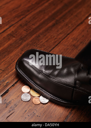 Primo piano di una calzatura uomo in piedi sul cambiamento, monete, denaro trovato sul concetto di pavimento Foto Stock