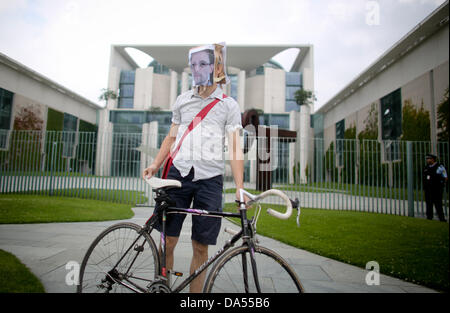 Berlino, Germania. 04 Luglio, 2013. Un attivista della democrazia sta con una maschera del ritratto di Edward Snowden davanti alla cancelleria tedesca a Berlino, Germania, 04 luglio 2013. Snowden realizzato il presunto Spionaggio di dati per gli Stati Uniti e la Gran Bretagna pubblico. Foto: KAY NIETFELD/dpa/Alamy Live News Foto Stock