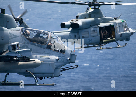 US Marine Corps UH-1W Super elicottero cobra e UH-1Y Venom in formazione sorvolare Kaneohe Bay Giugno 13, 2013 in Oahu, Hawaii. Foto Stock