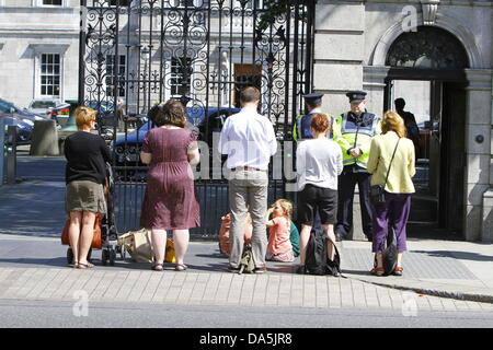 Dublino, Irlanda. 4 luglio 2013. Manifestanti stand al di fuori del Dail e leggere libri. Il Dail può essere visto in background. I dimostranti si fermò in silenziosa al di fuori del Dail (parlamento irlandese), la lettura di libri, per mostrare i loro sentimenti verso i banchieri e la politica di austerità al parlamento. La protesta è stata ispirata dalla permanente movimento di persone che ha dato origine a Istanbul la piazza Taksim. Credito: Michael Debets/Alamy Live News Foto Stock